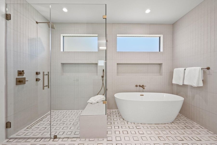 Full bath with tile walls, a soaking tub, a shower stall, and recessed lighting