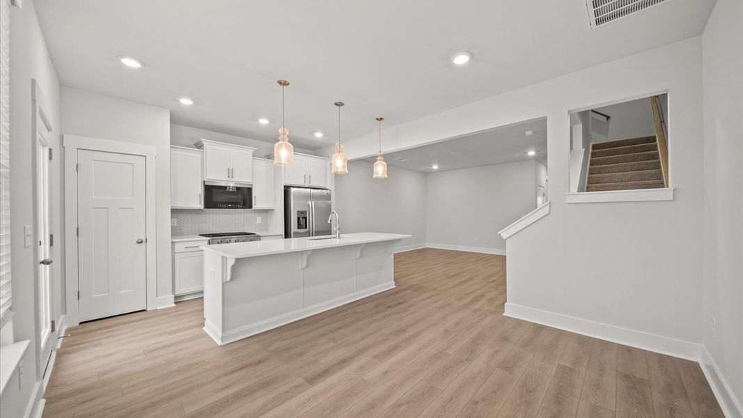 Tasteful kitchen with oversized island and stylish pendant lighting—crafted to high standards