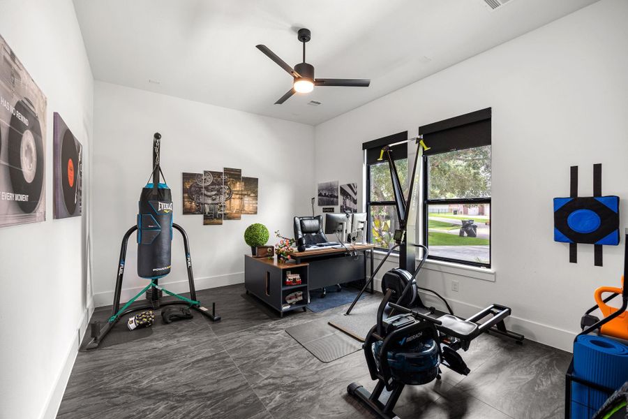 This room is a versatile space ideal for a home office or gym. Large windows provide natural light, and the sleek design includes a ceiling fan and black-out shades for comfort and privacy. This room is a versatile space ideal for a home office or gym. Large windows provide natural light, and the sleek design includes a ceiling fan and black-out shades for comfort and privacy.