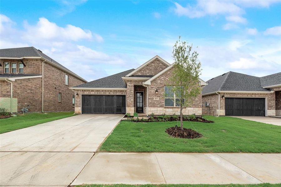 Front exterior of a new home in Spiritas Ranch, Little Elm, TX, highlighting curb appeal (Image 24). Front exterior of a new home in Spiritas Ranch, Little Elm, TX, highlighting curb appeal (Image 24).