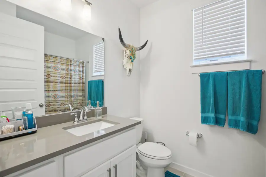 Bathroom with a shower with curtain, vanity, and tile patterned floors Bathroom with a shower with curtain, vanity, and tile patterned floors