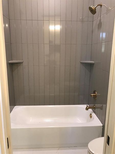 Bathroom featuring shower / bath combination and toilet