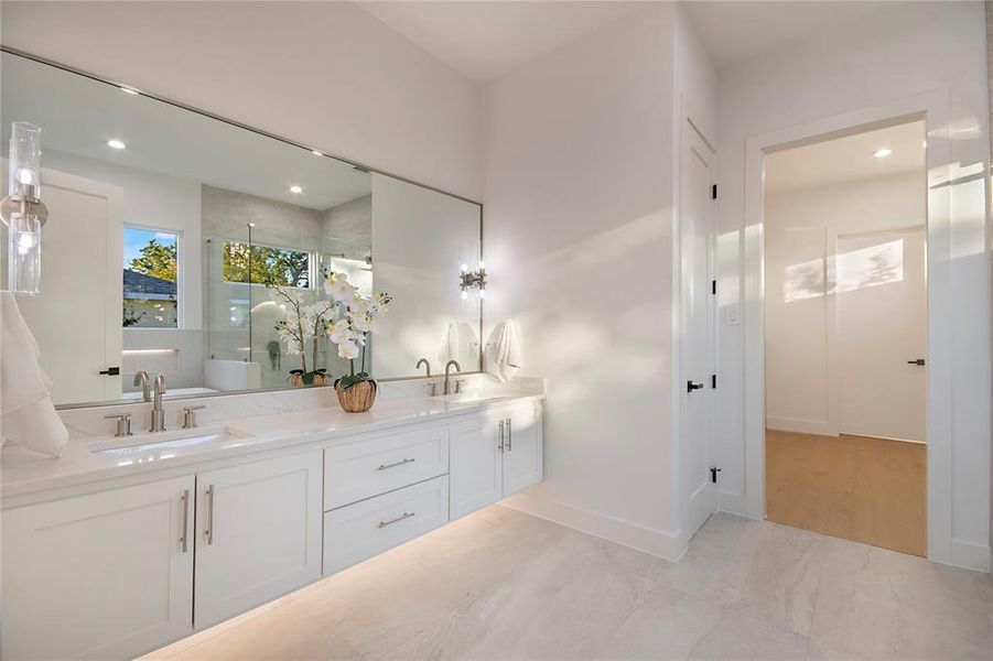 Bathroom featuring double vanity, recessed lighting, a stall shower, and a freestanding bath
