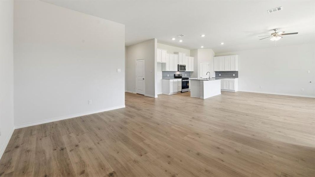 Unfurnished living room featuring ceiling fan, recessed lighting, and light wood-style floors