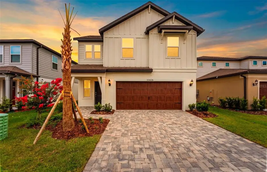 Front exterior of a new home in Vida's Way, Wesley Chapel, FL, highlighting curb appeal (Image 2). Front exterior of a new home in Vida's Way, Wesley Chapel, FL, highlighting curb appeal (Image 2).