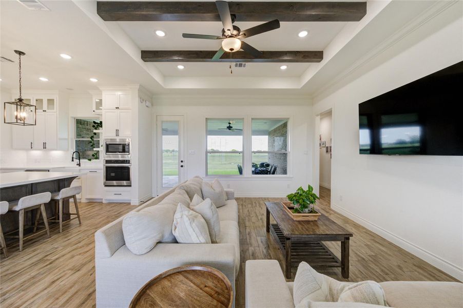 Living area with wood-beamed ceiling and views of the covered back patio