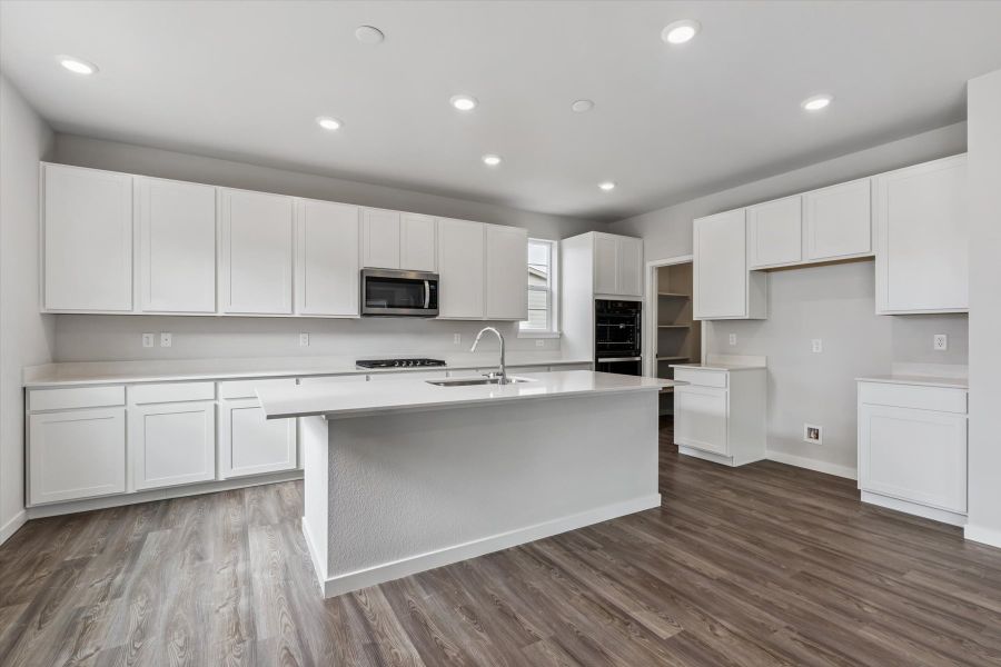 A kitchen with white cabinets.