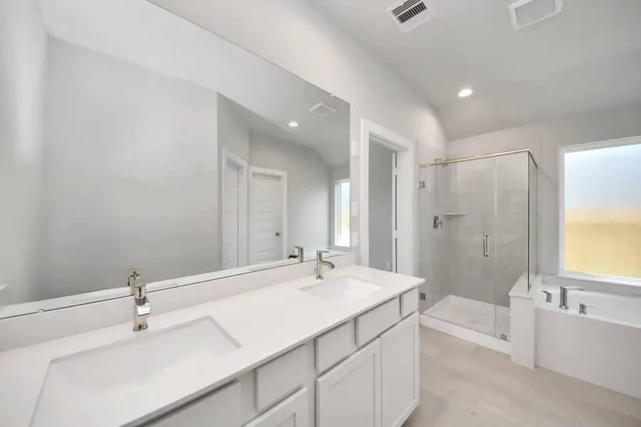 Elevate your daily routine at the elegant vanity, now equipped with double sinks, light countertops, modern hardware, and beautiful recessed lights. Sample photo of completed home with similar floor plan. Actual colors and selections may vary. Elevate your daily routine at the elegant vanity, now equipped with double sinks, light countertops, modern hardware, and beautiful recessed lights. Sample photo of completed home with similar floor plan. Actual colors and selections may vary.