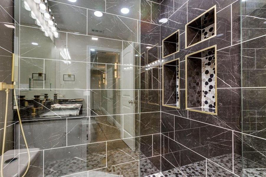 Full bath featuring tiled shower and vanity