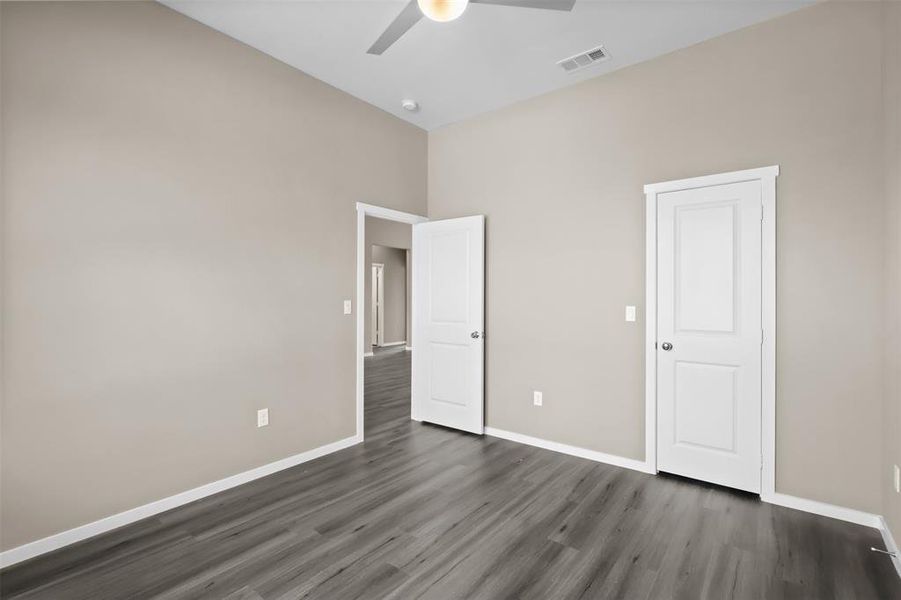 Unfurnished bedroom featuring dark hardwood / wood-style flooring and ceiling fan