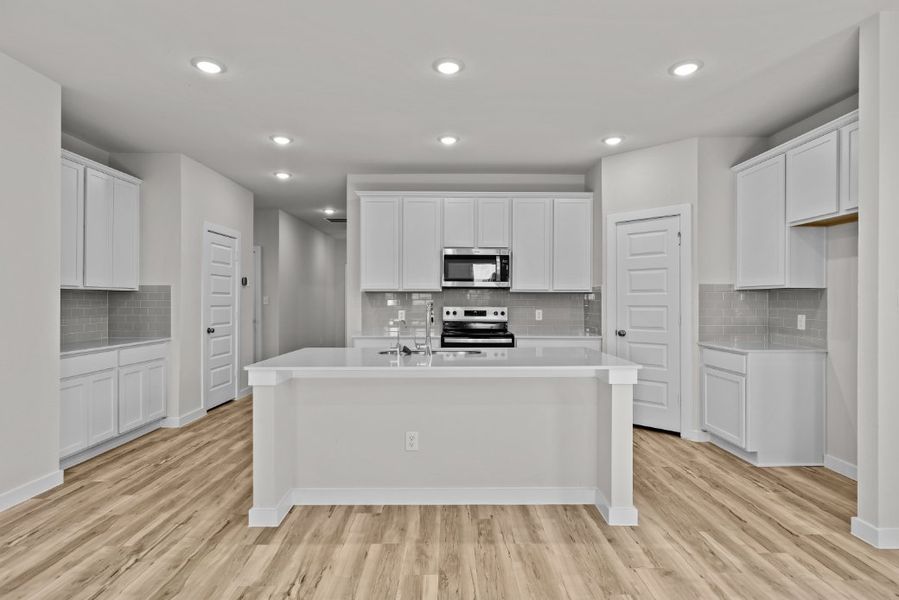 A kitchen with white cabinets.
