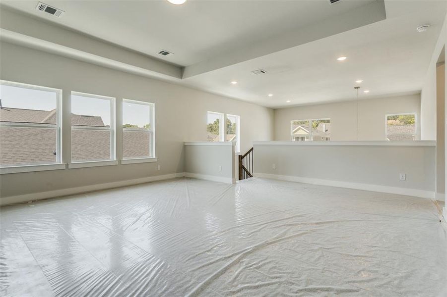 Unfurnished living room featuring a tray ceiling