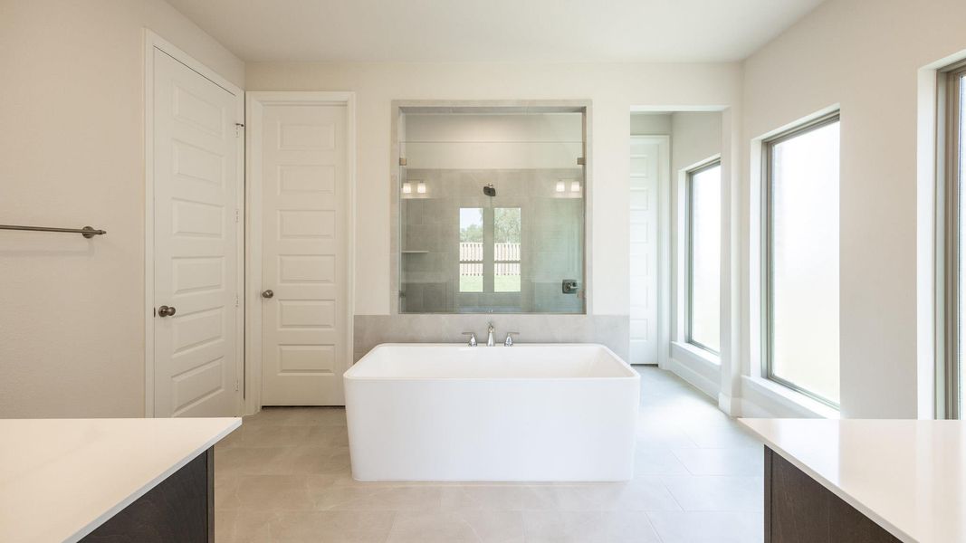 Bathroom with vanity, a shower stall, a freestanding tub, and light tile patterned floors
