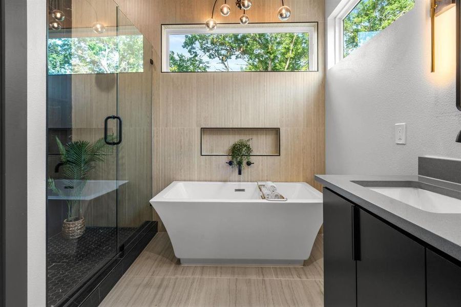 Full bathroom featuring vanity, a stall shower, and a soaking tub