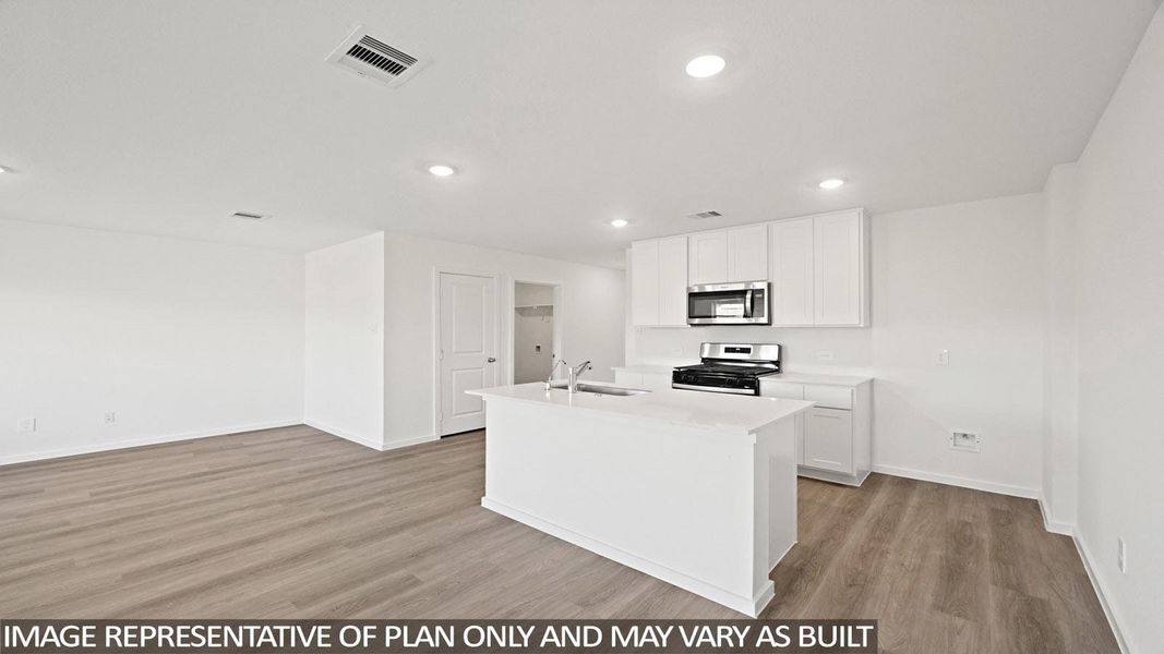Kitchen featuring light wood-type flooring, a center island with sink, stainless steel appliances, white cabinetry, and recessed lighting