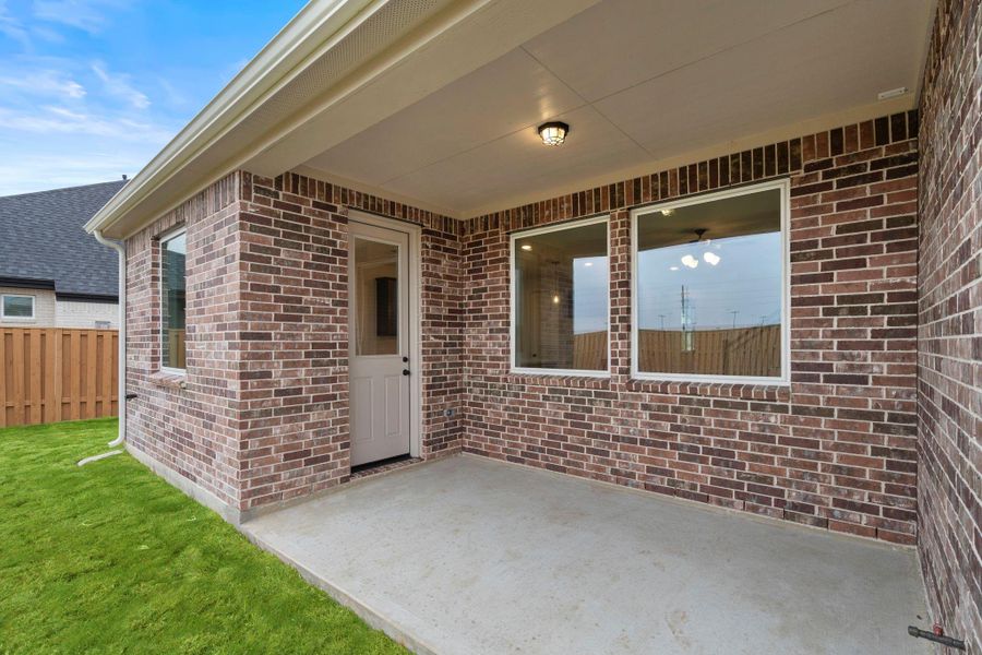 The covered patio is generously sized, providing ample space for various outdoor activities.