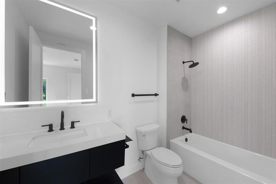Bathroom featuring shower / washtub combination, vanity, and recessed lighting