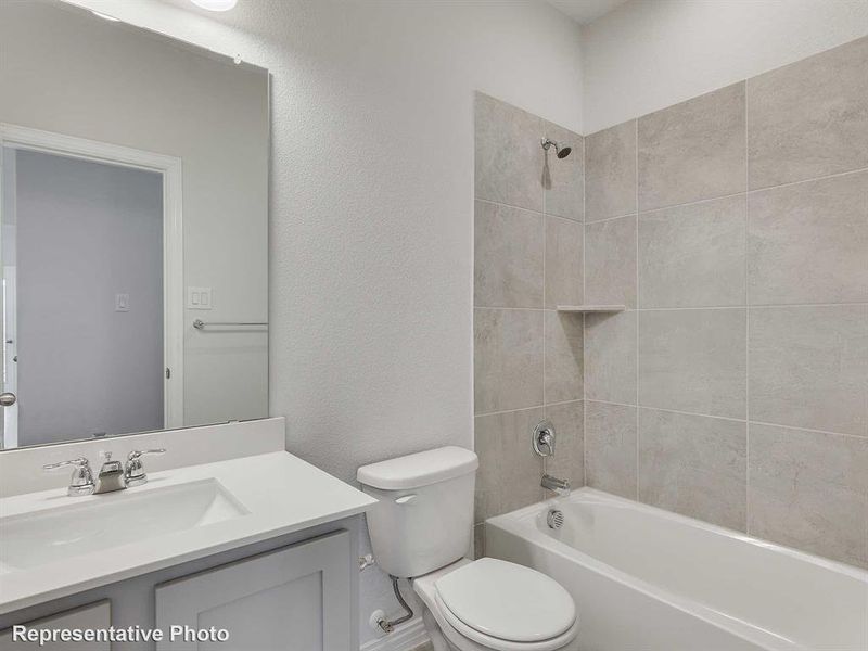 Bathroom featuring a textured wall,  shower combination, and vanity