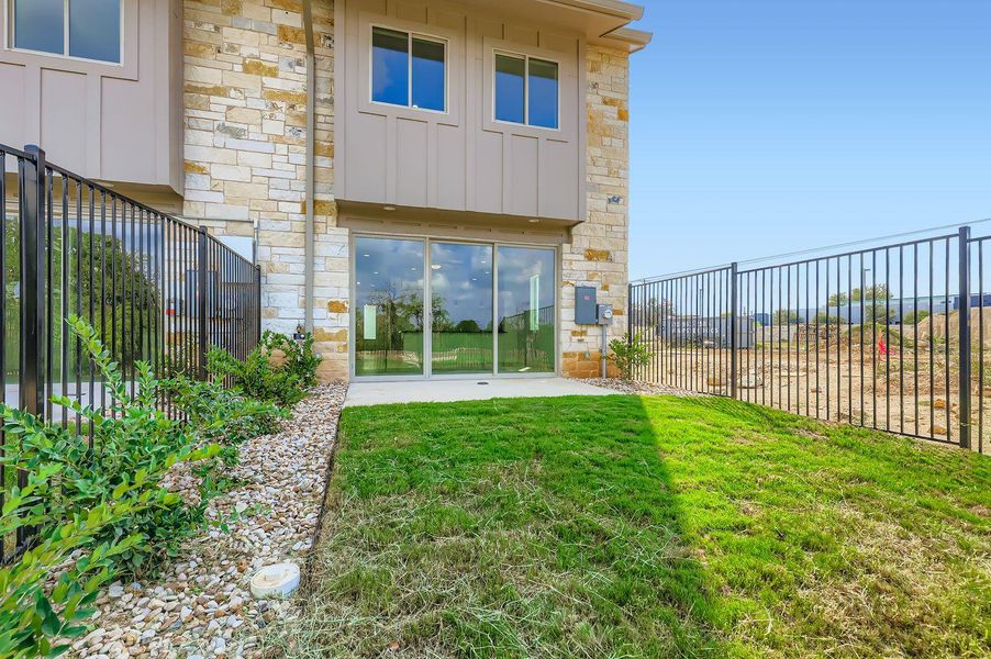 Back of property featuring board and batten siding, stone siding, and a patio area