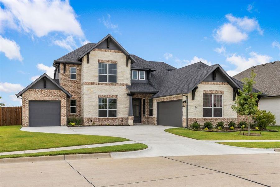 View of front of home featuring a garage and a front lawn