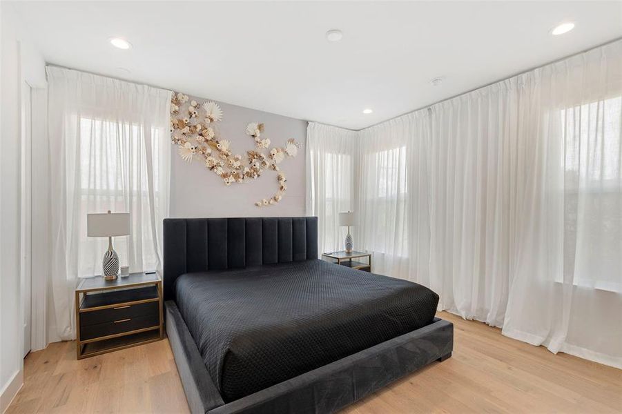 Master Bedroom with multiple windows and light hardwood / wood-style floors