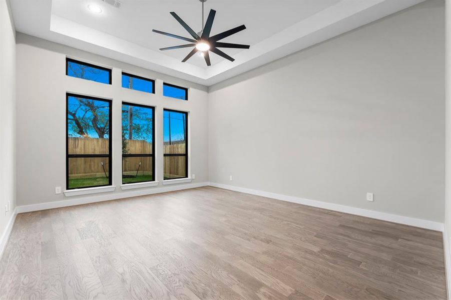 Spacious downstairs primary bedroom adorned with beautiful windows, including elegant transom windows.