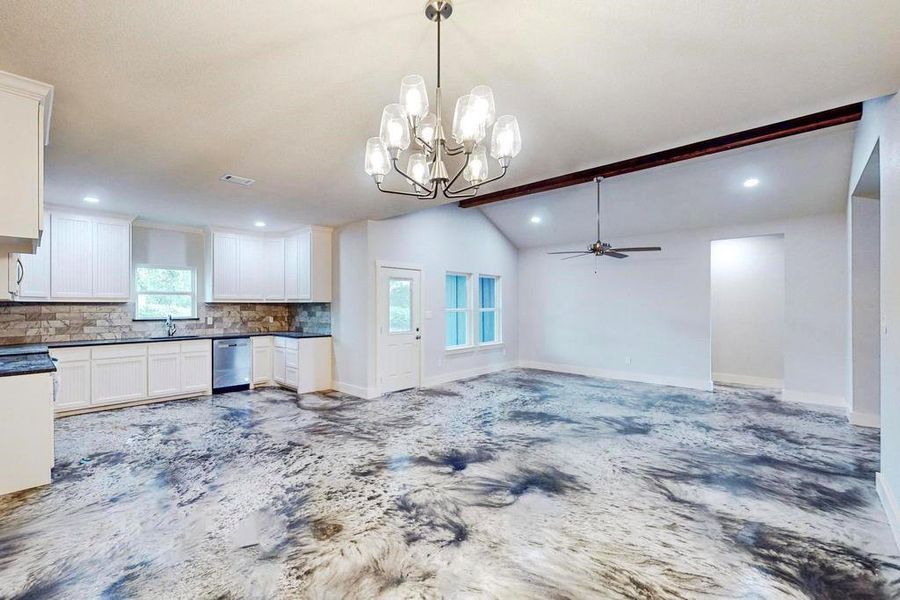 Kitchen with white cabinets, lofted ceiling with beams, ceiling fan with notable chandelier, stainless steel dishwasher, and decorative backsplash