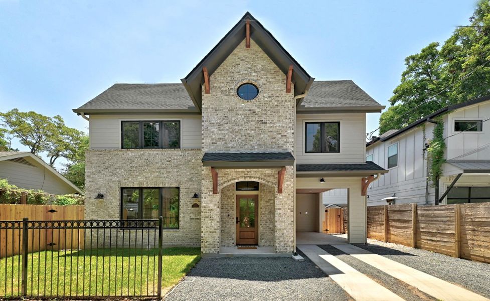 A modern two-story residence presents an inviting facade with light-colored brick and a distinctive round window. A modern two-story residence presents an inviting facade with light-colored brick and a distinctive round window.