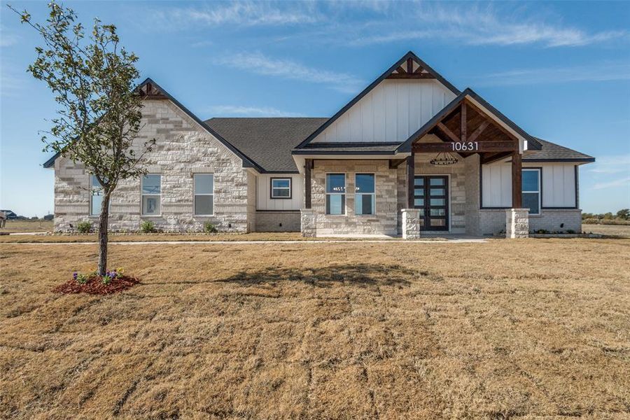 View of front of property featuring french doors, board and batten siding, a front lawn, and a shingled roof