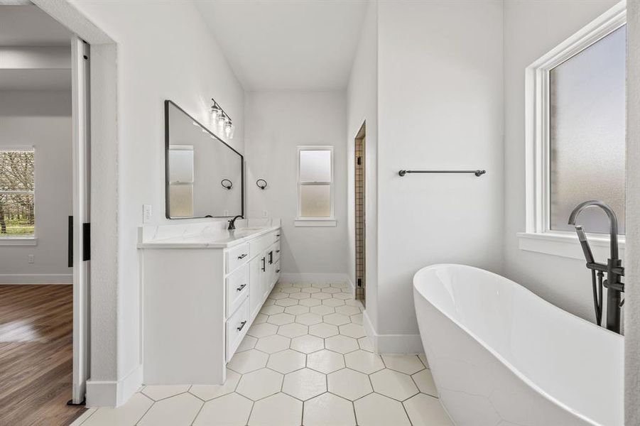 Bathroom featuring double vanity, a soaking tub, and a shower Bathroom featuring double vanity, a soaking tub, and a shower