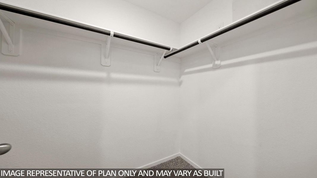 Spacious walk-in closet featuring white walls, durable shelving, and dual hanging rods