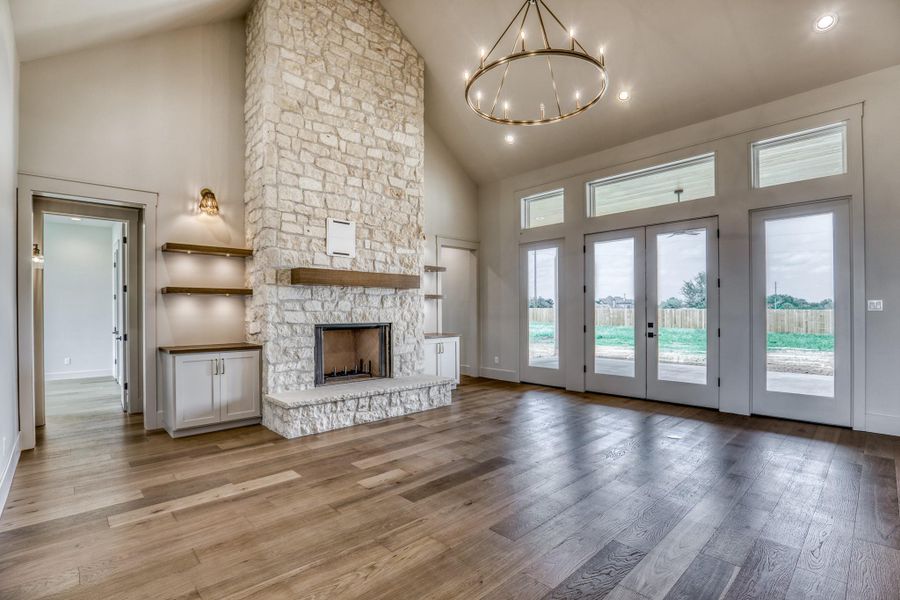 Living room with vaulted ceilings and stone fireplace.