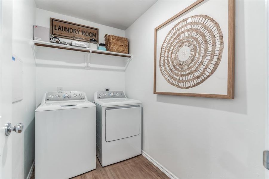 Laundry area featuring wood-type flooring and independent washer and dryer