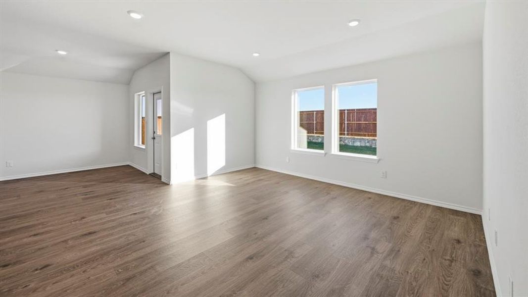 Unfurnished living room with vaulted ceiling, dark wood-style floors, and recessed lighting Unfurnished living room with vaulted ceiling, dark wood-style floors, and recessed lighting