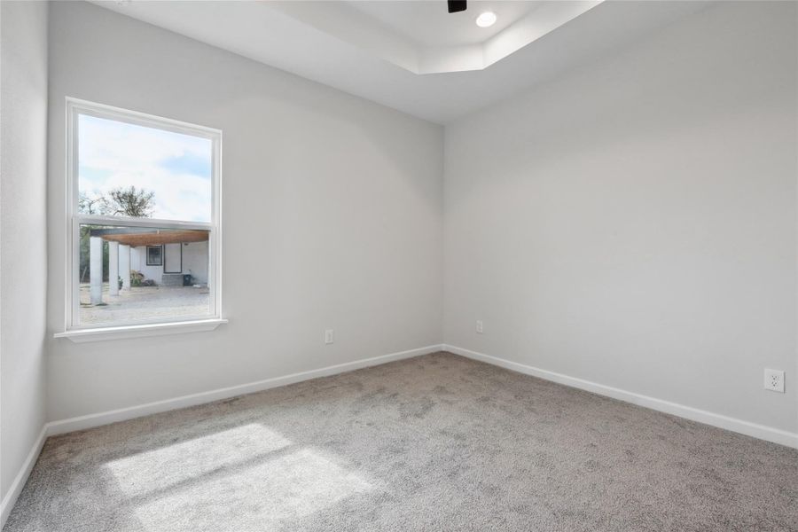 Carpeted empty room with plenty of natural light and baseboards Carpeted empty room with plenty of natural light and baseboards
