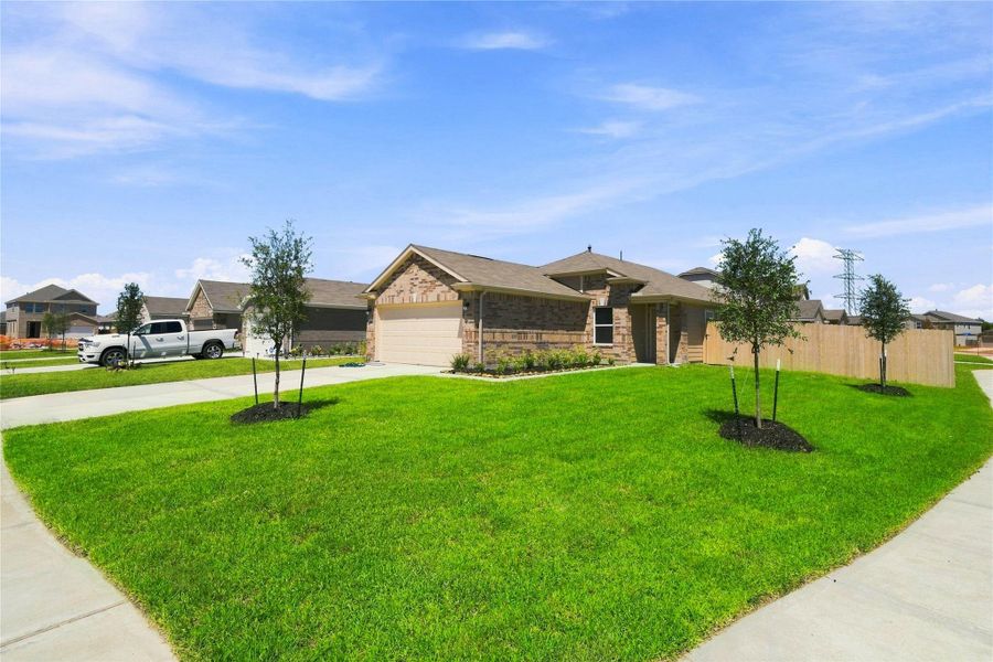 Additional perspective of large corner lot and the plush green landscaping.