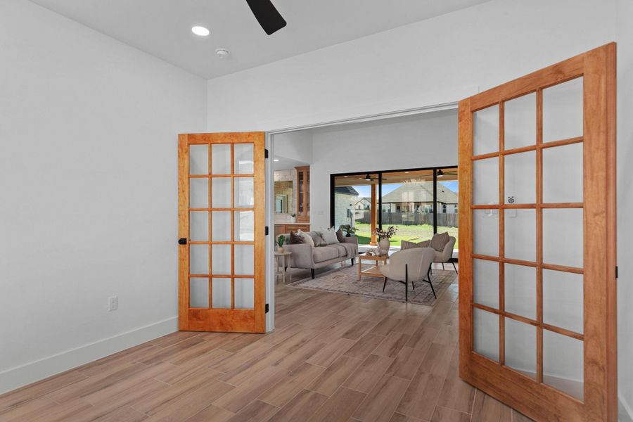 Spare room featuring wood tiled floors, french doors, a ceiling fan, and recessed lighting Spare room featuring wood tiled floors, french doors, a ceiling fan, and recessed lighting