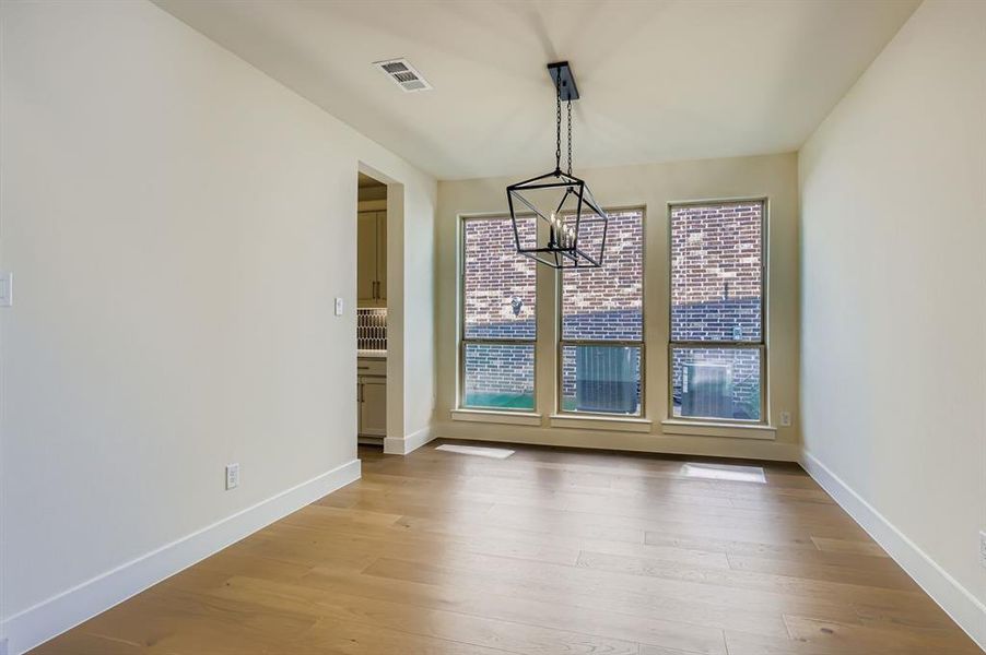 Unfurnished dining area with light wood-style flooring and a chandelier