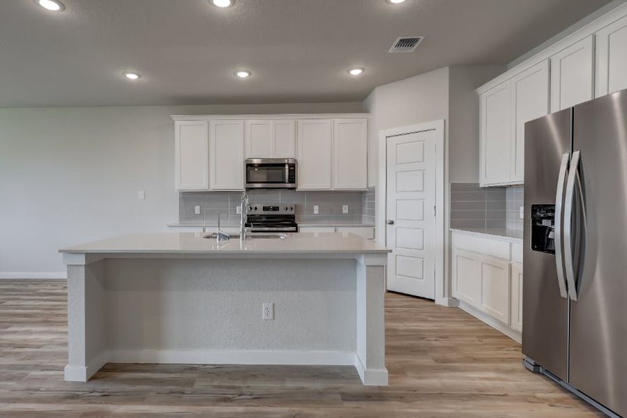 A kitchen with white cabinets.