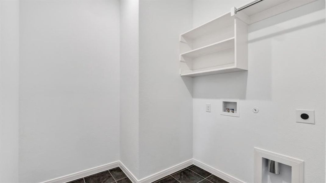 Washroom with hookup for an electric dryer, gas dryer hookup, dark tile patterned floors, and washer hookup