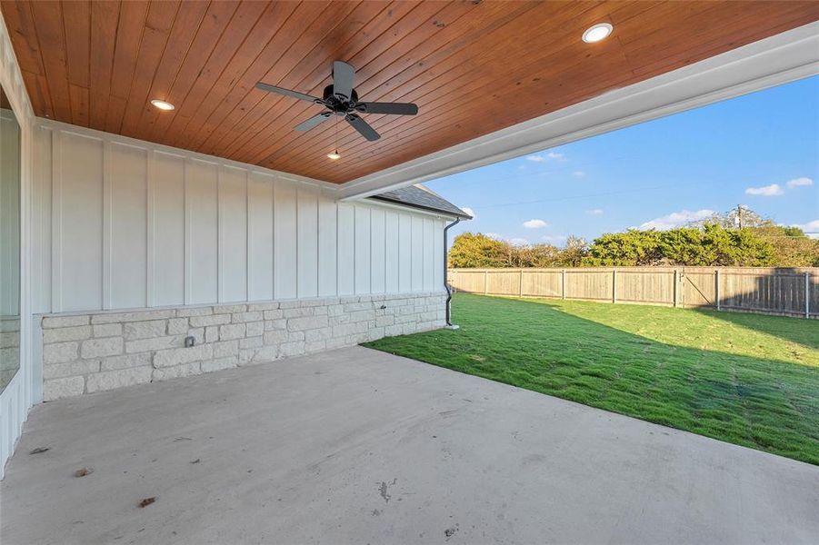 Fenced backyard featuring ceiling fan and a patio area