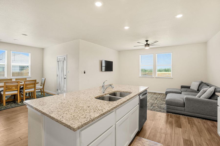 An open concept design seamlessly connects the kitchen to the living and dining areas, creating an inviting flow.