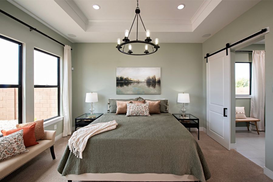 Primary suite with coffered ceiling and chandelier