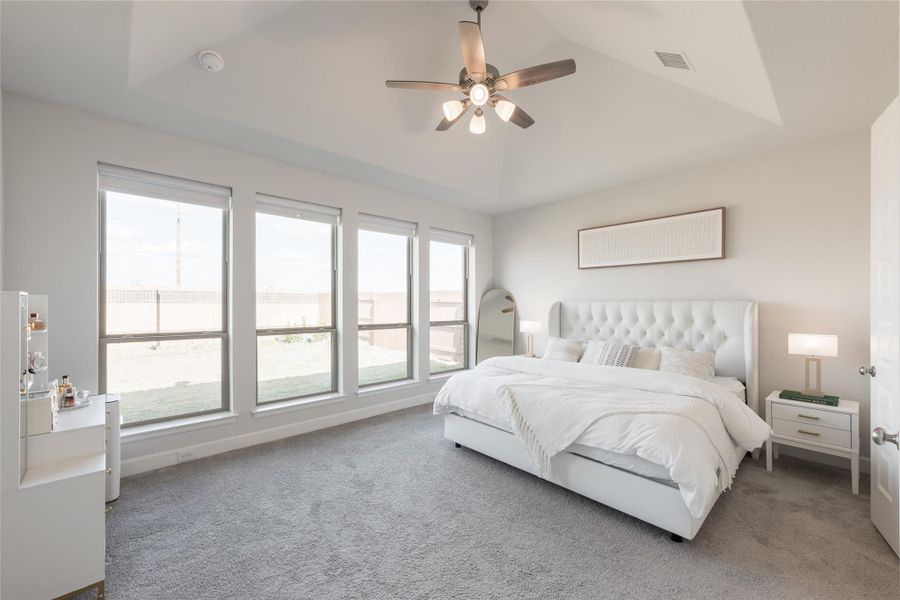 Primary bedroom features large windows offering plenty of natural light, a stylish ceiling fan, and a comfortable bed with modern decor. Primary bedroom features large windows offering plenty of natural light, a stylish ceiling fan, and a comfortable bed with modern decor.