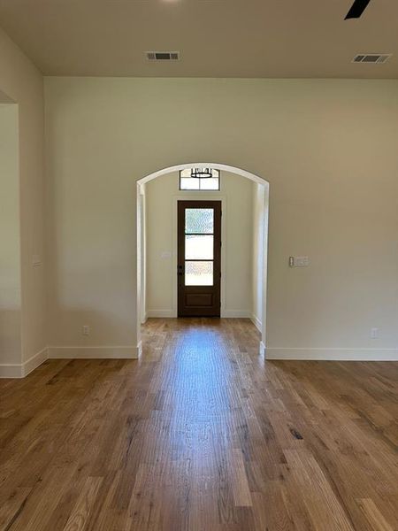 Entrance foyer with arched walkways and wood finished floors