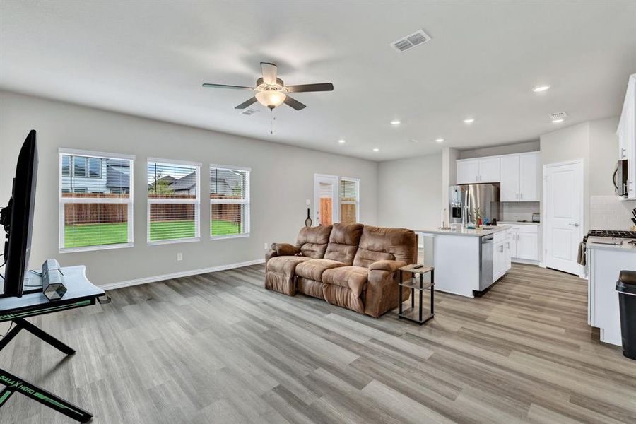 The property features an open-concept living area with light-toned flooring and recessed lighting