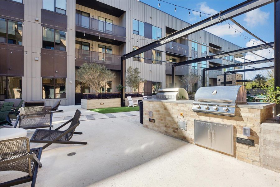 An inviting community patio with an outdoor kitchen, string lighting, and lounge seating. An inviting community patio with an outdoor kitchen, string lighting, and lounge seating.