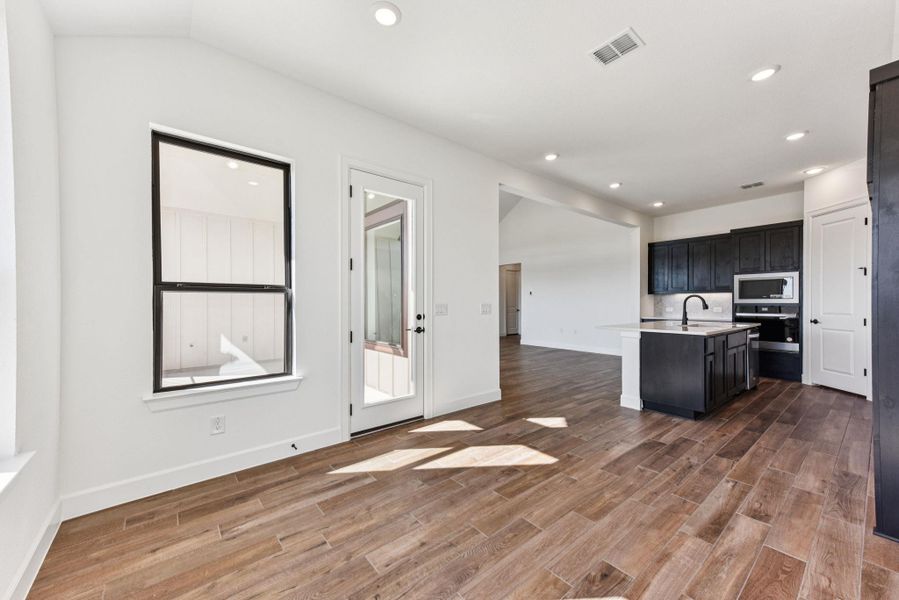 Kitchen with an island with sink, recessed lighting, open floor plan, appliances with stainless steel finishes, and dark wood finished floors