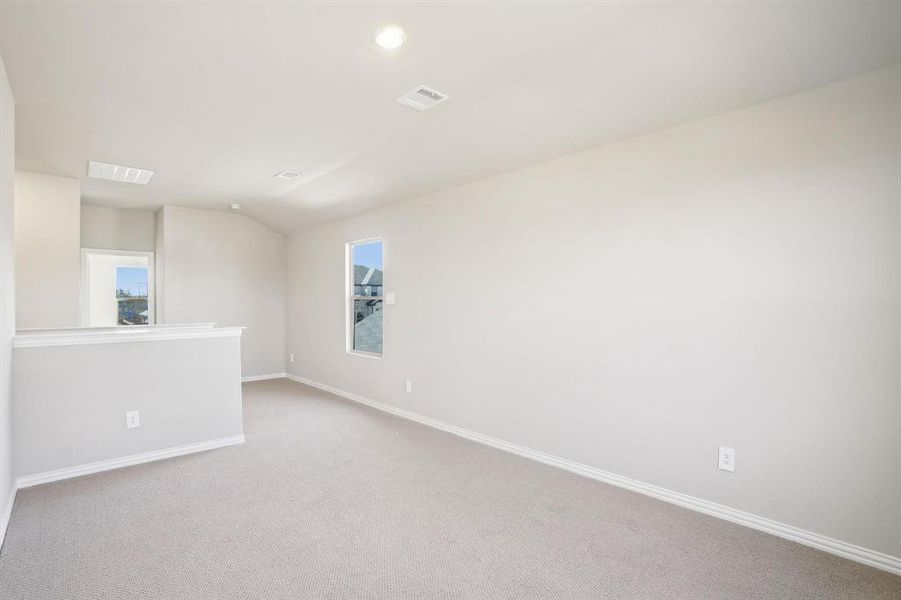 Carpeted empty room featuring vaulted ceiling and recessed lighting Carpeted empty room featuring vaulted ceiling and recessed lighting