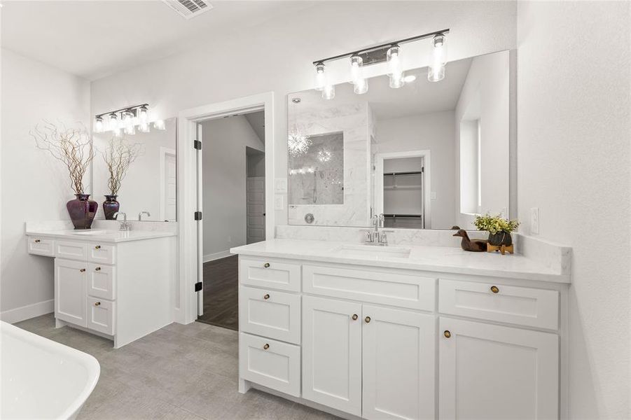 Bathroom with two vanities, a walk in closet, and a freestanding bath Bathroom with two vanities, a walk in closet, and a freestanding bath